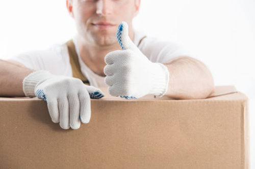 mover wearing gloves with arms on cardboard box giving thumbs up